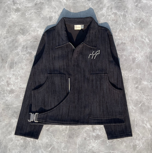 Black Corduroy jacket with a logo on a gray textured background